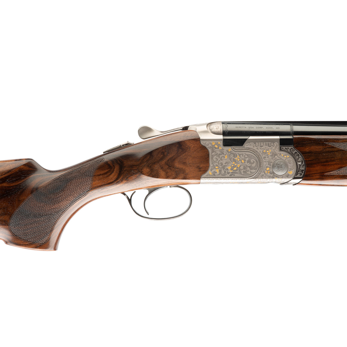 Close-up side view of a double-barrel shotgun showing the wooden stock, textured grip, engraved metal receiver, and trigger guard on a white background.
