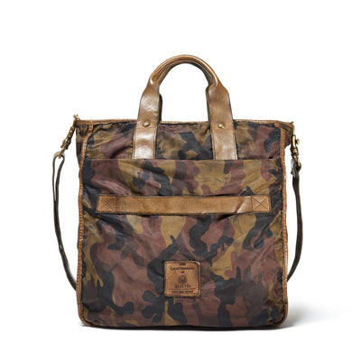 A camouflage tote bag with brown leather handles and accents.