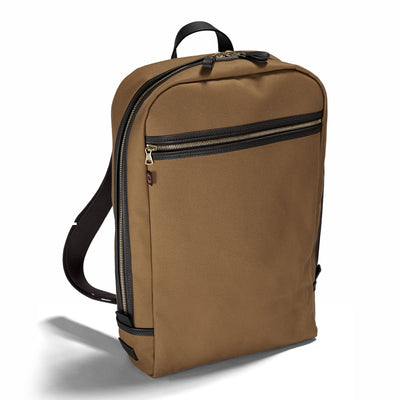 A tan-colored British Twill zipped backpack with a full zip opening, leather handle, and multiple pockets.
