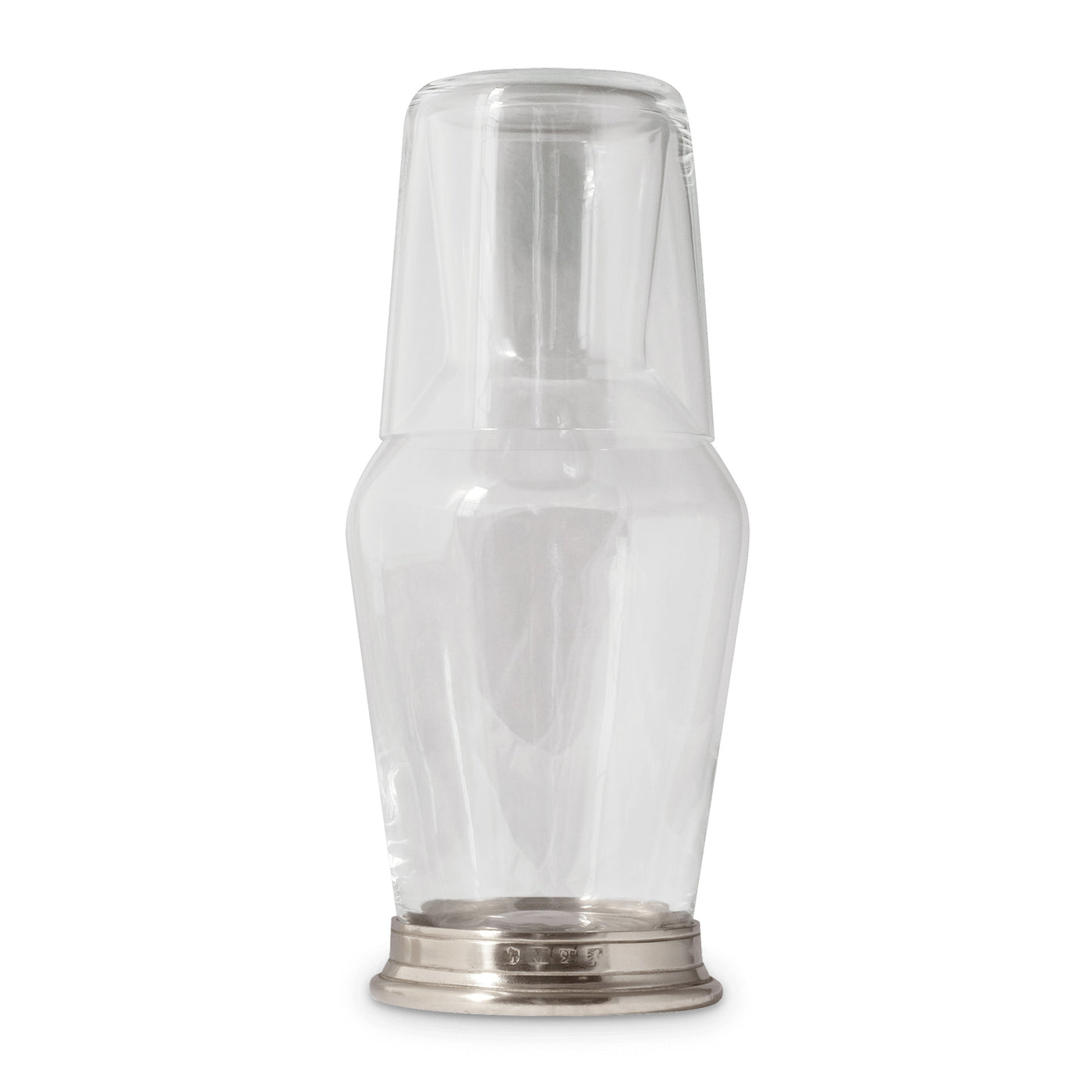 A clear glass bedside carafe with a matching tumbler, featuring a pewter band on the carafe and a glass lid on the tumbler.