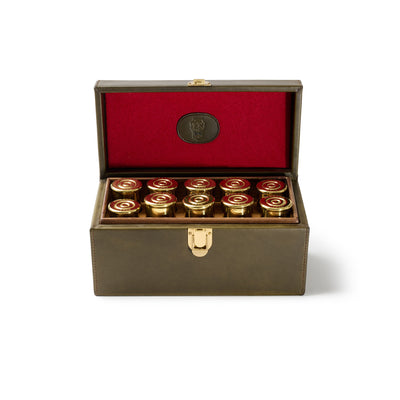 Brown leather box with red interior containing gold and red cylindrical objects on a white background