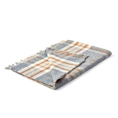 A grey double face check lambswool throw with fringes, laid out on a plain surface.